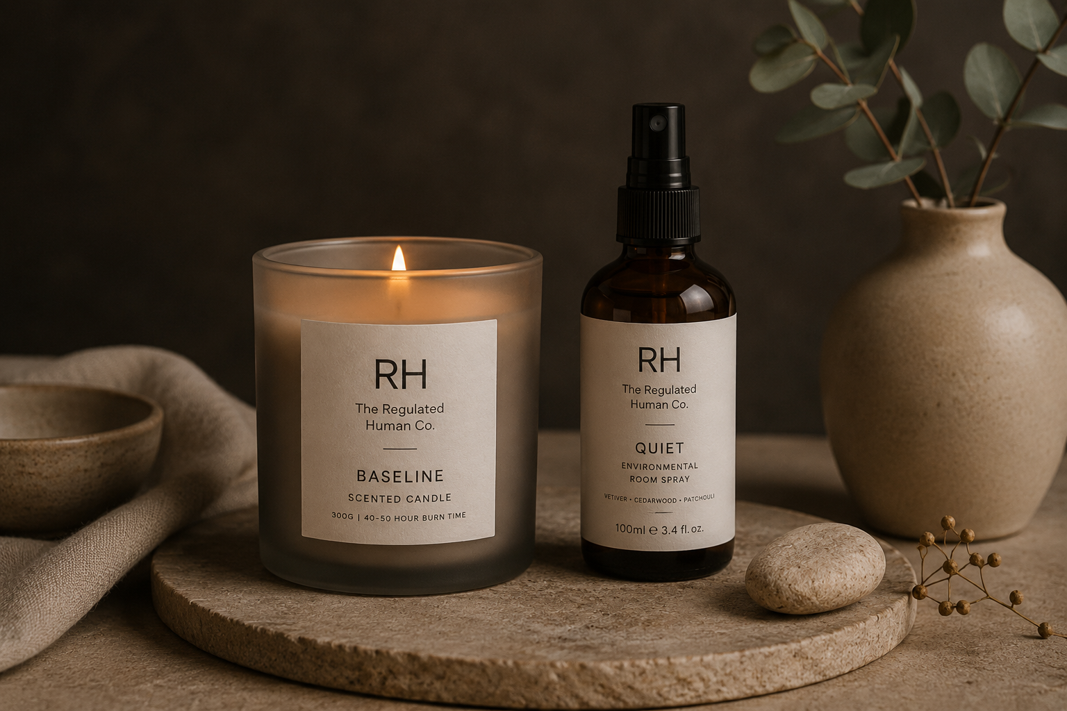 RH candle and bottle on a wooden surface with a dark background